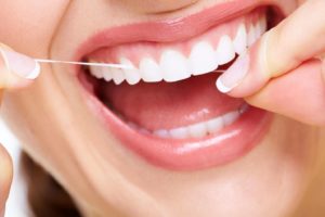 Woman floss beautiful white teeth