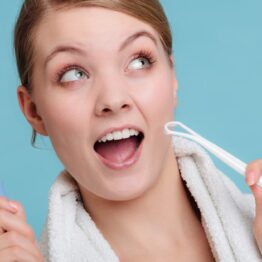 Young girl with electric brush and tongue scrape