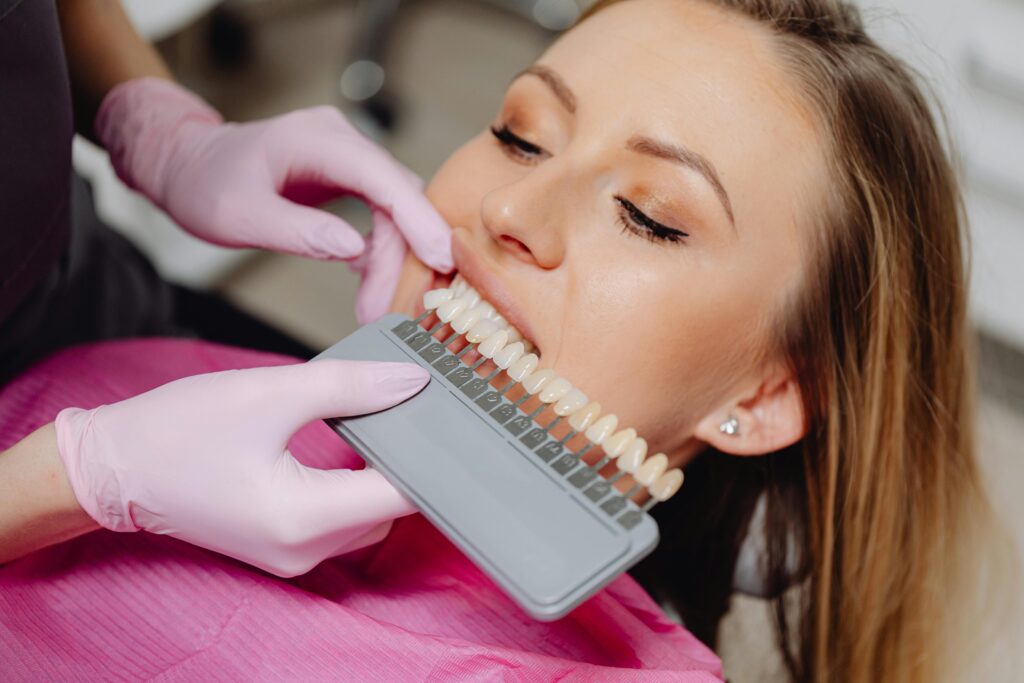 A woman selecting the shade of her teeth whitening at a dental clinic
